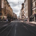 people walking on side walk beside brown building