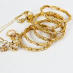 gold chain necklace on white surface